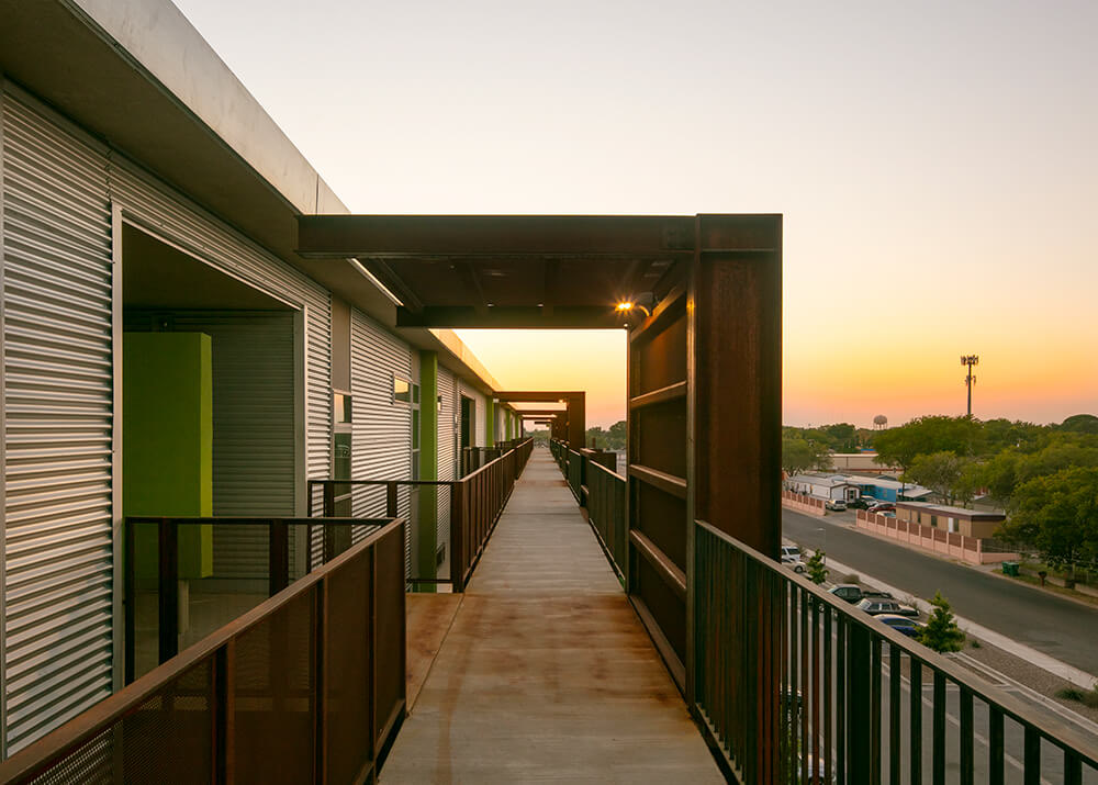 Upper-floor walkway at Playa Escondida looking out over east Hobbs at sunset