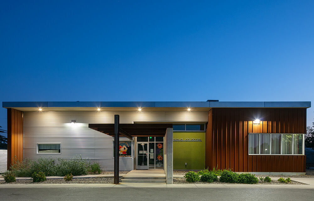Community building and leasing office at Playa Escondida at dusk with its green accent entry